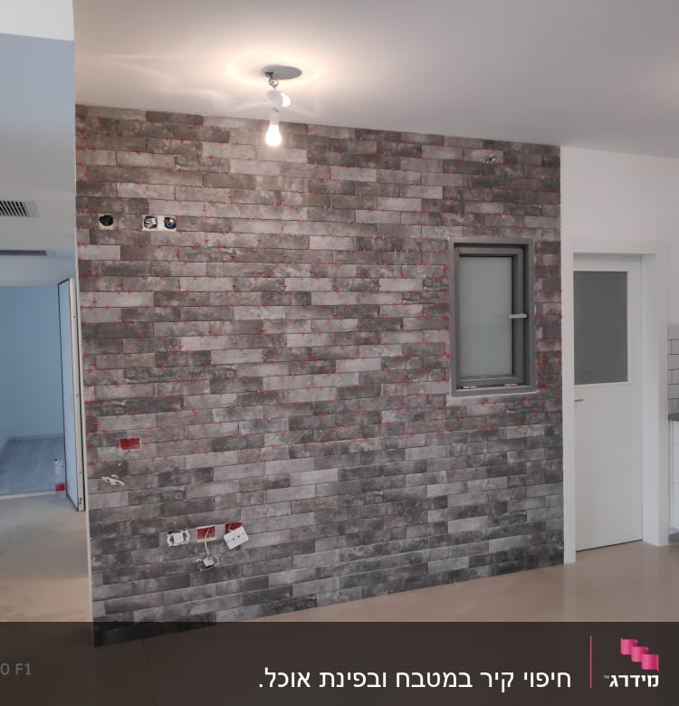 קיר עם אריחים אפורים, שקעי חשמל חשופים